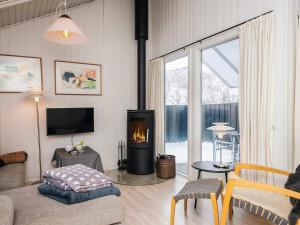a living room with a fireplace and a couch at 4 star holiday home in Vejers Strand in Vejers Strand +37 photos