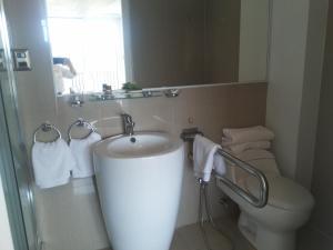 een badkamer met een wastafel, een toilet en een spiegel bij Ruta Hotel Alto La Cruz in Los Ángeles