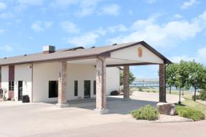 a building with pillars in a parking lot at Super 8 by Wyndham Chamberlain SD in Chamberlain