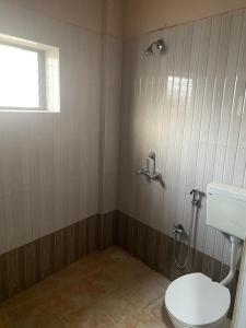 a bathroom with a toilet and a sink and a window at Hotel Beach Avenue in Calangute +22 photos