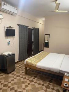 a bedroom with a bed and a television in it at Hotel Beach Avenue in Calangute