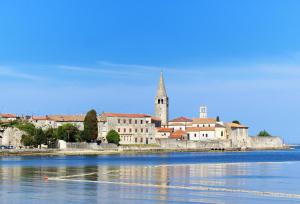 a town on the water with a church at Apartments Urban Porec in Poreč