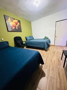 a bedroom with two beds and a chair in it at Departamento Mateo'S 505 in Ciudad Acuña