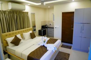 a hotel room with two beds with towels on them at Deva Towers in Puttaparthi