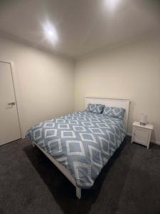 a bedroom with a bed and a night stand at Peaceful Room in Wyndham Vale for Stay in Wyndham Vale