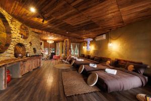 a room with several beds in a room with a stone wall at Puluong Qui E Ora in Lũng Tiềm