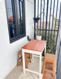 a wooden table and two chairs on a balcony at Rama Shinta Guesthouse & Coffee Yogyakarta in Yogyakarta
