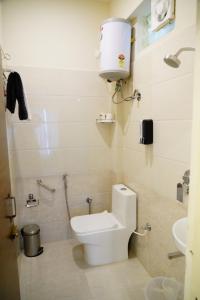 a small bathroom with a toilet and a sink at Deva Towers in Puttaparthi