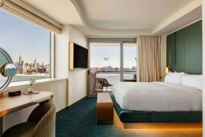a hotel room with a bed and a large window at W Hoboken in Hoboken +128 photos