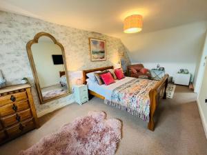 a bedroom with a bed and a large mirror at Number 2, Spacious Rooms, Near Ironbridge! in Telford