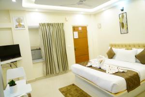 a bedroom with a bed with a baby on it at Deva Towers in Puttaparthi