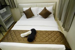 a bedroom with a bed with a black and white pillow at Deva Towers in Puttaparthi