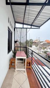 a balcony with a table and benches on a building at Rama Shinta Guesthouse & Coffee Yogyakarta in Yogyakarta