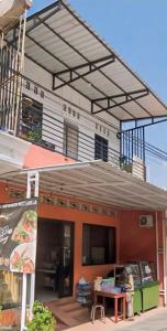 a building with awning and a table in front of it at Rama Shinta Guesthouse & Coffee Yogyakarta in Yogyakarta +3 photos
