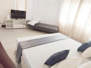 a bedroom with two beds and a couch and a television at Peak Lodge in Kandy
