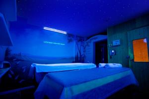 a room with a blue wall and a blue bed at Vip's Motel in Lonato del Garda