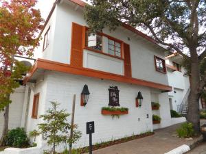 a white building with windows and flowers on it at Tally Ho Inn in Carmel