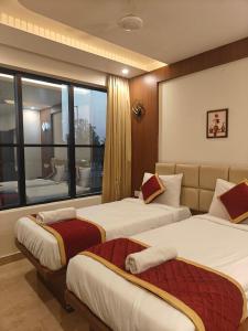 a hotel room with two beds and a large window at SN Comforts in Bangalore +49 photos