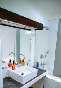 a bathroom with a white sink and a shower at EVASION Bungalow Harmonie in Sarraméa