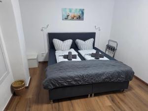 a bedroom with a black bed with white pillows at Gästehaus Strandbake in Cuxhaven