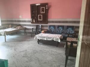 a room with two beds and chairs in it at VIPIN homestay in Bāghpat