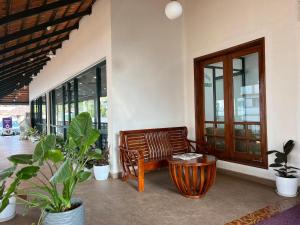a room with a bench and some potted plants at HOTEL DWARA in Subrahmanya