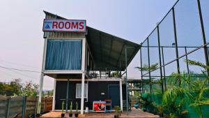 a building with a red rooms sign on it at Amigos rooms in Annavaram +3 photos