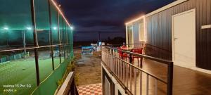 a balcony of a building at night with a baseball field at Amigos rooms in Annavaram