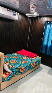 a bedroom with a bed with a floral comforter at Amigos rooms in Annavaram