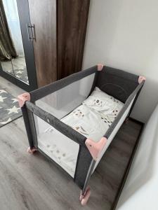 a baby crib with a bed in a room at Apartment PMS in Veľká Mača