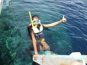 a woman in the water with a fishing pole at Moalboal Bamboo Guest House in Moalboal
