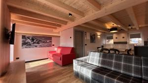 a living room with a red chair and a couch at Livigno Chalets in Livigno