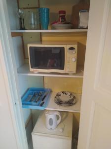 a small kitchen with a microwave and a toilet at Villa Alice room 2 in Tampere