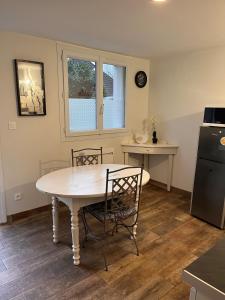 a kitchen with a table and chairs and a refrigerator at L'escapade in Bourg-en-Bresse +20 photos