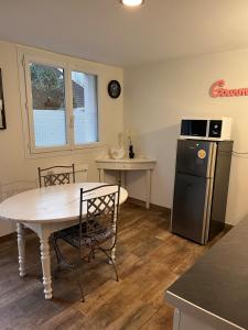 a kitchen with a table and a refrigerator at L'escapade in Bourg-en-Bresse