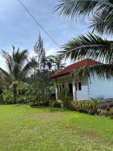 a small house with a red roof next to the ocean at Senaru Gateway homestay in Senaru