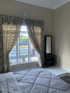 a bedroom with a bed and a large window at Homestay kampung moden in Pendang