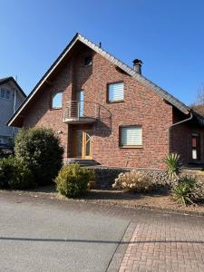 a brick house with a balcony on a street at Ferienwohnung Fröse in Altenbeken