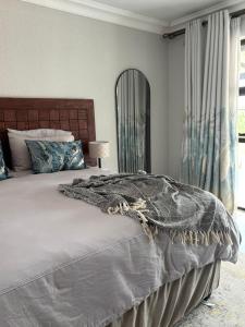 a bedroom with a large bed and a mirror at Sebeshong Guest House - Moletjie in Ga-Komape