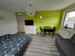 a bedroom with a bed and a table and a television at Daniels Gästezimmer in Dockweiler +5 photos