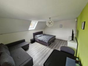 a living room with a couch and a bed at Daniels Gästezimmer in Dockweiler