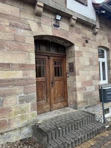 a wooden door on a brick building with a stone steps at Appartement 3 in Diemelstadt 