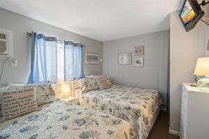 a bedroom with two beds and a tv in it at 6701 Atlantic Ave, Unit 301 in Wildwood Crest +22 photos
