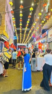 a woman in a blue dress standing in a market at Heaven Hostel in Ho Chi Minh City