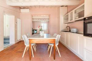 a kitchen and dining room with a wooden table and chairs at Romantico appartamento nel centro storico in Cortona