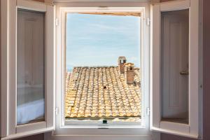 a window with a view of a roof at Romantico appartamento nel centro storico in Cortona