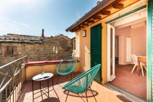 a balcony with two chairs and a table on it at Romantico appartamento nel centro storico in Cortona