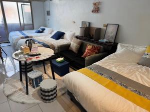 a living room with three beds and a table at Lukang Hongyu Hostel in Lukang