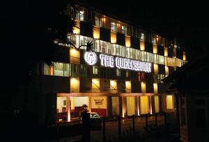 un edificio iluminado por la noche con un reloj en él en The Queensburry City Hotel en Nuwara Eliya