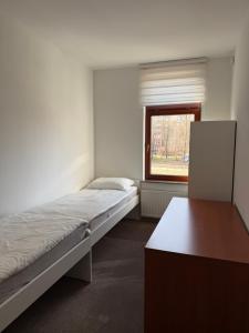 a room with two beds and a table and a window at JustInRent Next by Gallery Szpitalna 4D-2 in Legnica